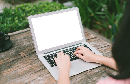 Women are using a laptop with a blank screen on the table in the coffee shop  with clipping path on screen. mock upの写真素材