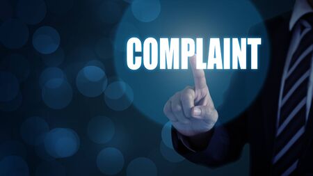 Businessman pointing the text Complaints button on virtual screens.の写真素材