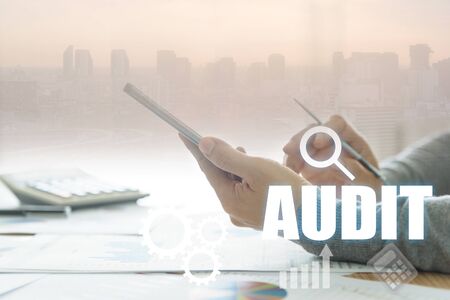 Accountants are using a smartphone to help analyze the data on the table.の写真素材