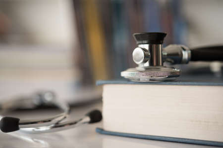 stethoscope on medical guide book for doctor learning treatment at hospital.  medical education learning concept.の写真素材