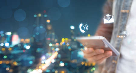 CONTACT US, Hand of a businessman holding a mobile smartphone with the icon. Contact us connection concept with copy space.の写真素材