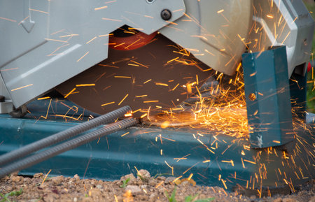 Workers are cutting steel bars using electric steel cutters for construction.