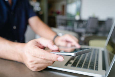 Business people using cell phones and laptops in the cafe.の写真素材