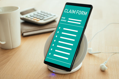 Insurance claim concept. The mobile smartphone is placed on a wireless fast charger on the screen...