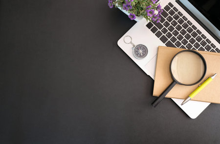 Worktable black leather workspace with office supplies and copy space with laptop and notebook. View...