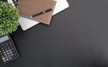 Worktable black leather workspace with office supplies and copy space with laptop and notebook. View from above.の写真素材