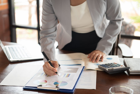 Business women calculated and reviewing data in financial statement. Accounting , Invest , Auditing Concept.の写真素材