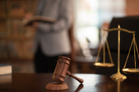 Judge gavel and scales of justice with lawyer reading law books at legal library. concept of...