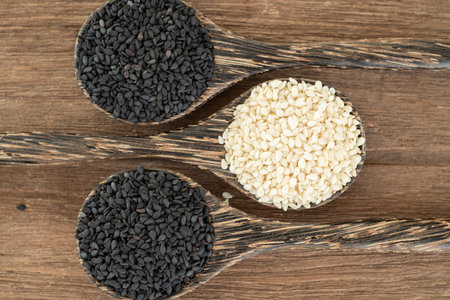 White sesame and Black sesame seed on wooden spoon. Healthy food and drink concept.