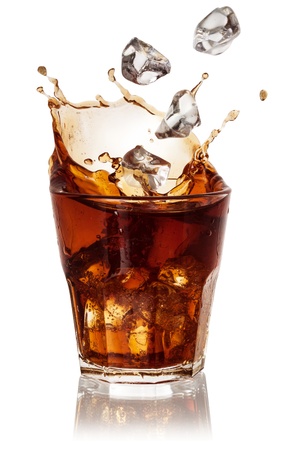 Cola glass with falling ice cubes over white.の写真素材