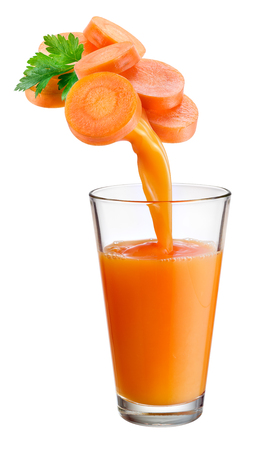 Fresh juice pours from carrot into the glass isolated on white background.の写真素材