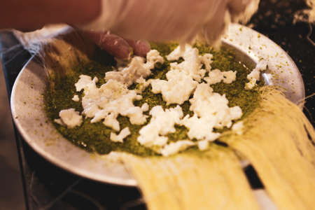 Turkish dessert kunefe, kunafa, kadayif with pistachio powder and cheese hot eaten a sweetの写真素材