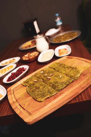 Turkish dessert kunefe, kunafa, kadayif with pistachio powder and cheese hot eaten a sweetの写真素材