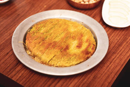 Turkish dessert kunefe, kunafa, kadayif with pistachio powder and cheese hot eaten a sweetの写真素材