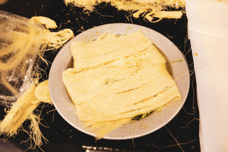 Turkish dessert kunefe, kunafa, kadayif with pistachio powder and cheese hot eaten a sweet