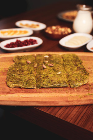 Turkish dessert kunefe, kunafa, kadayif with pistachio powder and cheese hot eaten a sweet