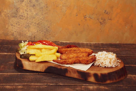 Doner kebab is lying on the cutting board. Shawarma with meat, onions, salad lies on a dark old wooden tableの写真素材