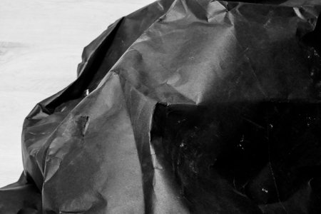 black creased crumpled paper background grunge texture backdropの写真素材