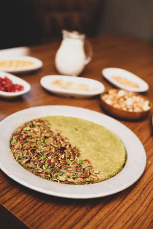 Turkish dessert kunefe, kunafa, kadayif with pistachio powder and cheese hot eaten a sweetの写真素材