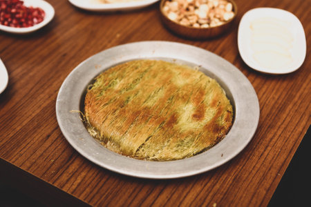 Turkish dessert kunefe, kunafa, kadayif with pistachio powder and cheese hot eaten a sweetの写真素材