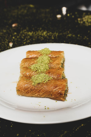 Turkish dessert kunefe, kunafa, kadayif with pistachio powder and cheese hot eaten a sweet