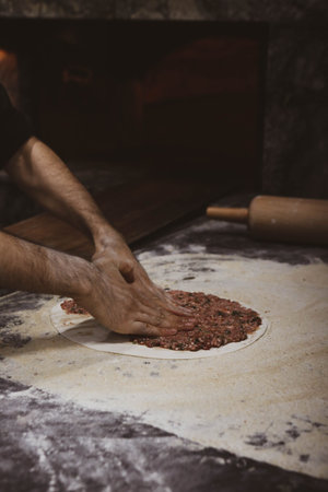 Making a turkish pizza or lahmacun - fast food and popular street food in Mediterranean countries.