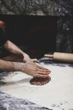 Making a turkish pizza or lahmacun - fast food and popular street food in Mediterranean countries.の写真素材