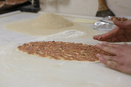 Making a turkish pizza or lahmacun - fast food and popular street food in Mediterranean countries.