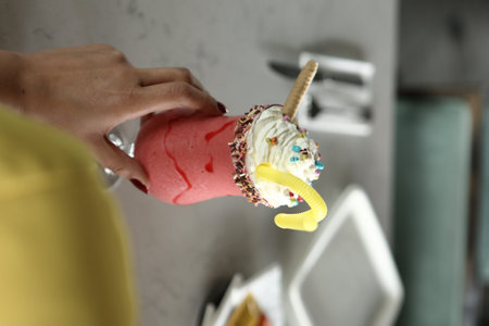 Glass of raspberry milkshake with whipped cream and fresh raspberries