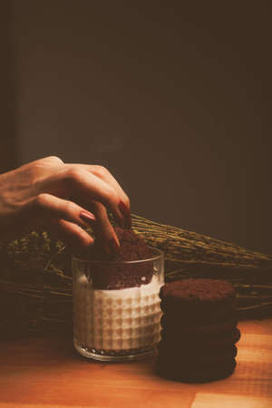 Dipping delicious cookies in a glass of milkの写真素材