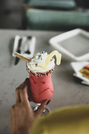 Glass of raspberry milkshake with whipped cream and fresh raspberriesの写真素材