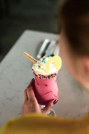 Glass of raspberry milkshake with whipped cream and fresh raspberriesの写真素材