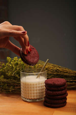 Dipping delicious cookies in a glass of milkの写真素材