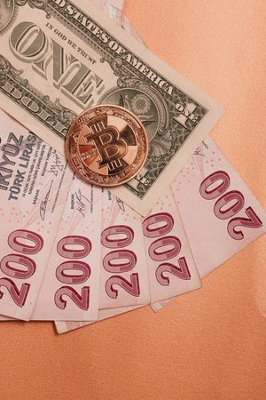 Turkish lira banknotes, US Dollars and bitcoin coin