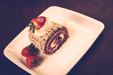 Board with delicious cake on tableの写真素材