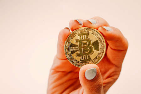 A young girl holds dollars cash and bitcoin with her hands, Different type of new generation banknotes and bitcoinの写真素材