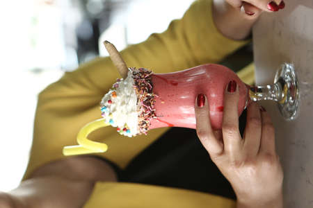 Glass of raspberry milkshake with whipped cream and fresh raspberriesの写真素材