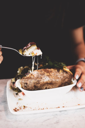 Baked kumpir potato stuffed with the cheese, sausage, olives, peppers and cornの写真素材