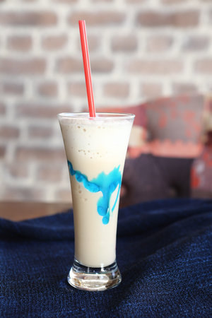 Iced coffee with milk. Iced coffee latte. Woman holding glass cup of iced coffee.