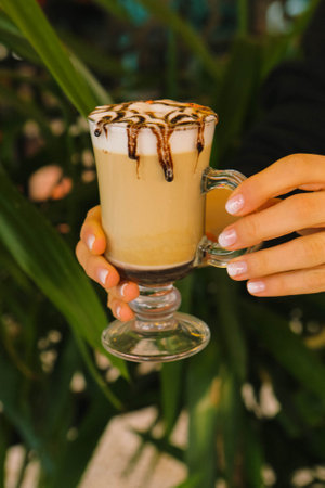 Iced coffee with milk. Iced coffee latte. Woman holding glass cup of iced coffee.の写真素材