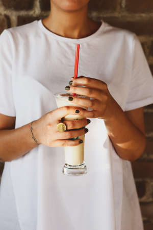 Iced coffee with milk. Iced coffee latte. Woman holding glass cup of iced coffee.の写真素材