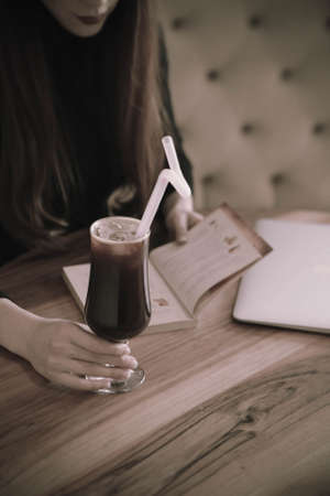Iced coffee with milk. Iced coffee latte. Woman holding glass cup of iced coffee.の写真素材