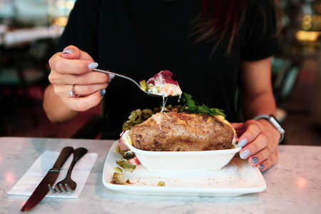 Baked kumpir potato stuffed with the cheese, sausage, olives, peppers and cornの写真素材
