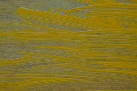 close up of yellow oil paint texture on canvas. abstract background