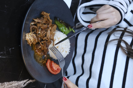 Woman eating rice with meat in the restaurant. Close-up.の写真素材