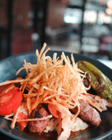 Fried sausage with vegetables on a plate in a restaurant. Selective focus.の写真素材