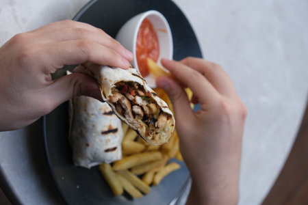 Tortilla wrap with grilled chicken and french fries in a restaurantの写真素材