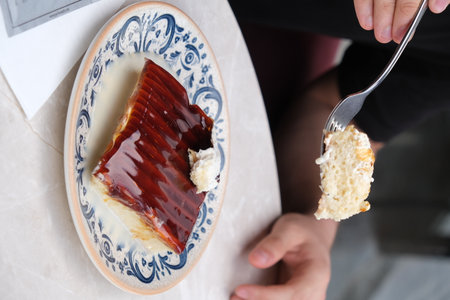 Delicious cheesecake with strawberry jam on plate in cafe, closeupの写真素材