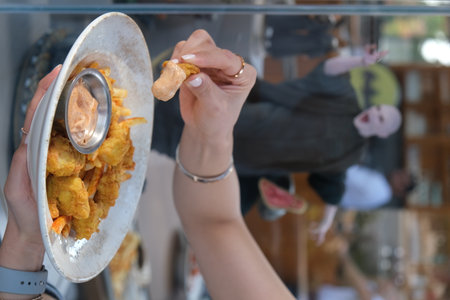 Closeup of a woman holding a plate of deep fried chicken nuggetsの写真素材