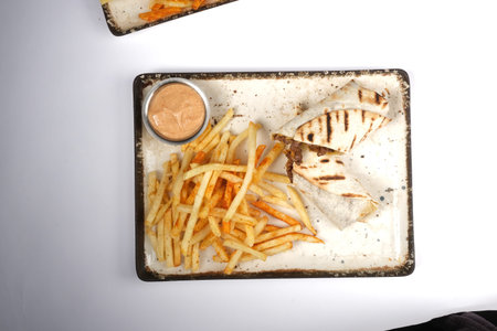 Chicken wrap and french fries on a white background